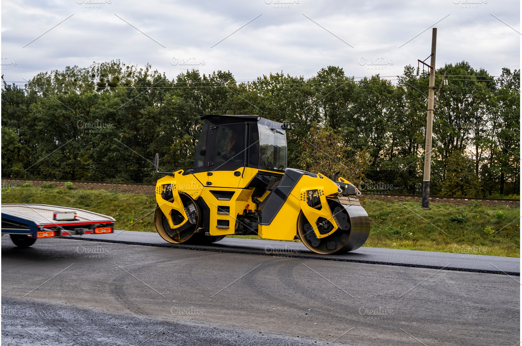 Heavy asphalt road roller that press, an Industrial Photo by volodymyrshtun13795