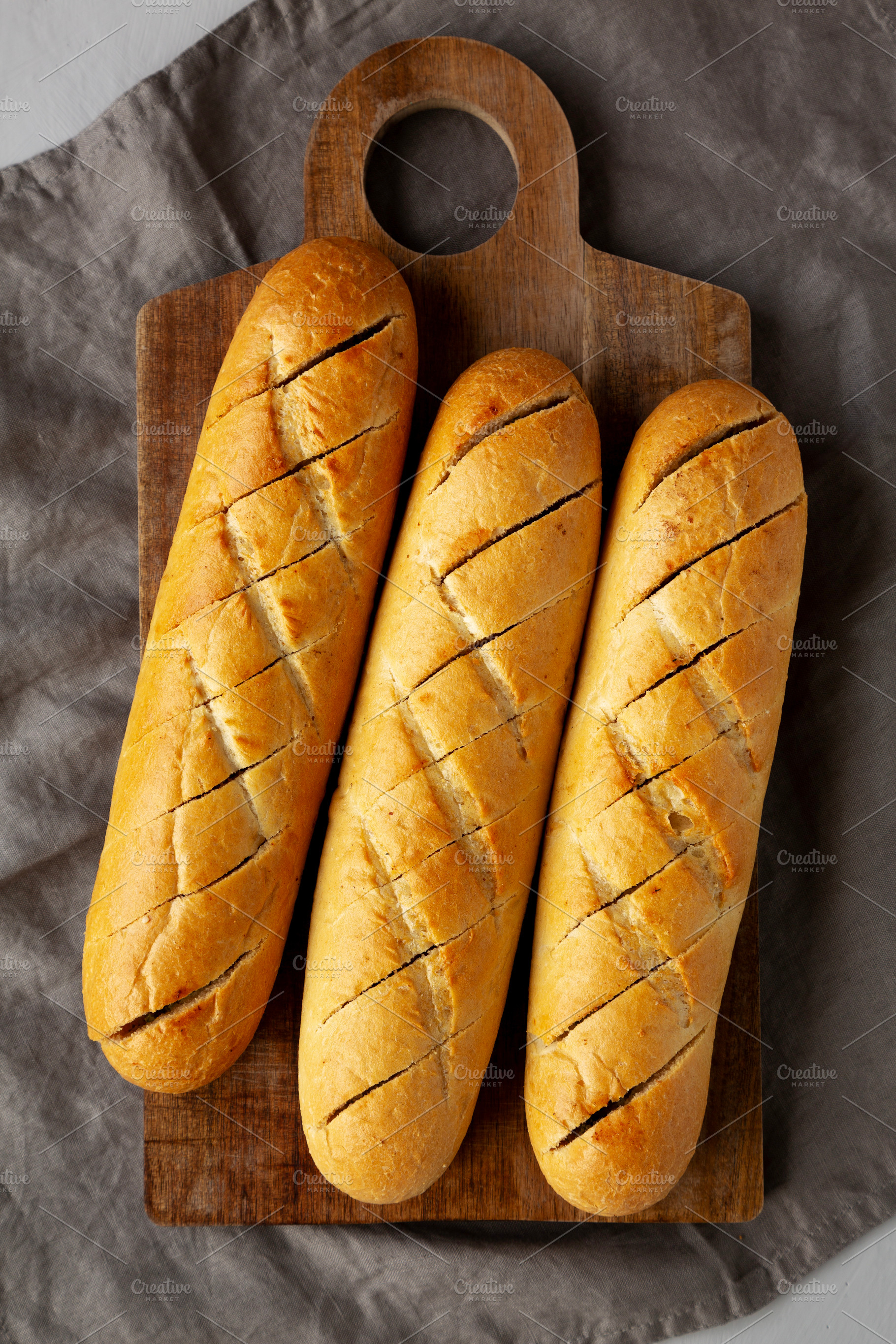 Homemade French Baguette with Garlic Filling on a wooden board,, a Food & Drink Photo by LiudmylaChuhunova