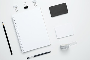 Monochrome stationery items. On a white background, an empty mock up notebook,, a Photo by matucha