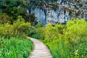 Wooden pathway above water at featuring croatia, plitvice, and waterfall, a Nature Photo by Leonid Andronov