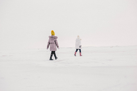 two girls walk on the frozen sea