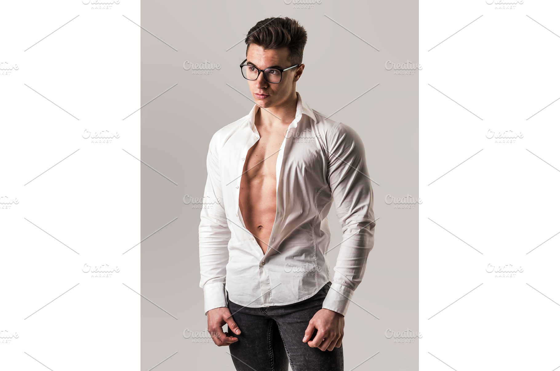 Young muscleman undressing in studio, a Person Photo by ArtOfPhotos photo store