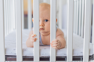 Sad baby looking through the bars of, a Person Photo by Elizaveta Galitskaya