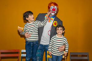 Clown playing with children at birthday party, a Person Photo by karrastock
