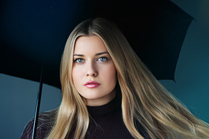Young woman with blonde hair holding an umbrella, looking at cam, a Person Photo by Studio ANNA