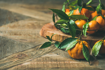 Fresh tangerines with leaves on board, copy space, a Holiday Photo by Foxys