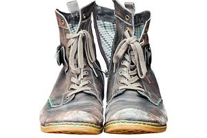 Old worn out leather boots isolated