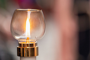 Burning candle illuminating a glass lantern during a religious procession, a Holiday Photo by Antonio Gravante Market