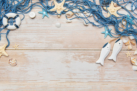 Fishing net, seashells, starfishes and fishes on rustic white wo