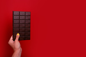 Close-up of a female hand with yellow nail polish holding a larg, a Food & Drink Photo by Ales Munt