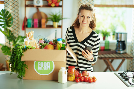 happy young female with food box in kitchen, a Person Photo by Alliance Images