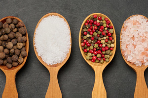 Horizontal row of wooden spoons with black pepper, salt, mixed p, a Food & Drink Photo by ndanko