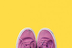 Old sneakers on yellow background, a Beauty & Fashion Photo by BOOCYS