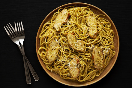 Homemade Pesto alla Genovese Pasta on a Plate on a black backgro, a Food & Drink Photo by LiudmylaChuhunova