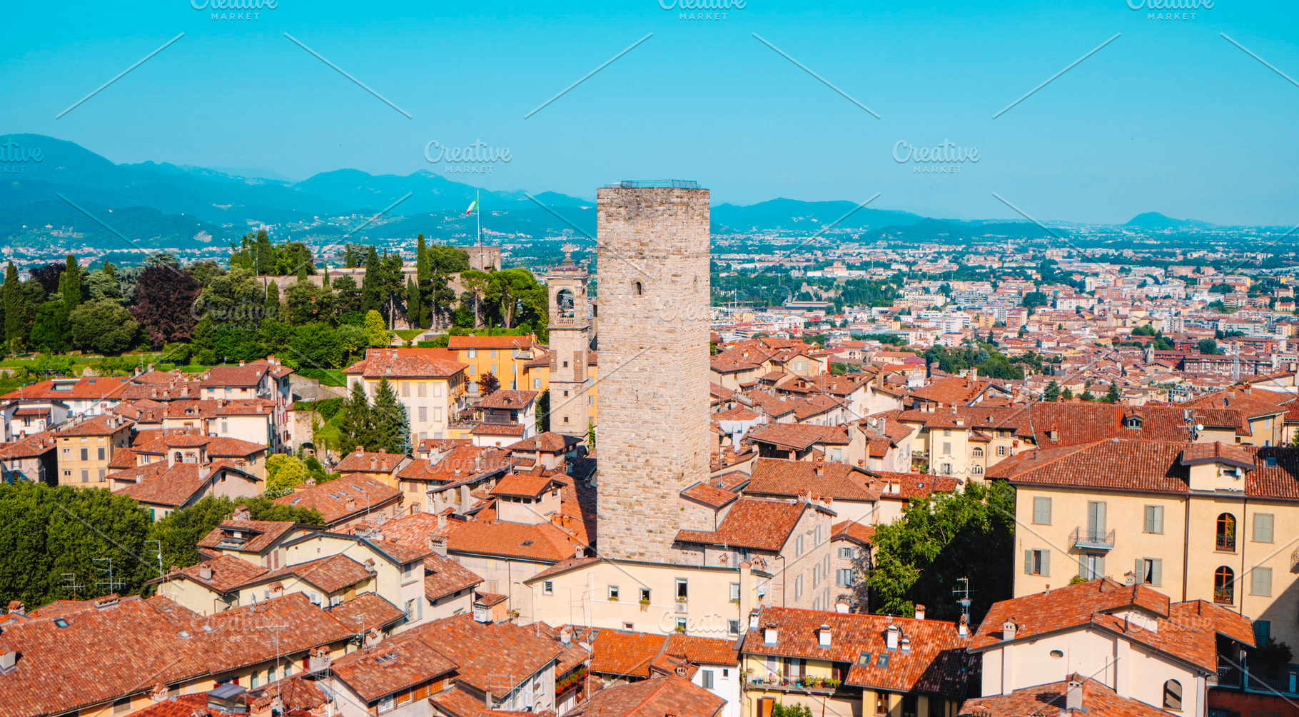 a medieval stone tower among rooftops in Bergamo, a Photo by Nito