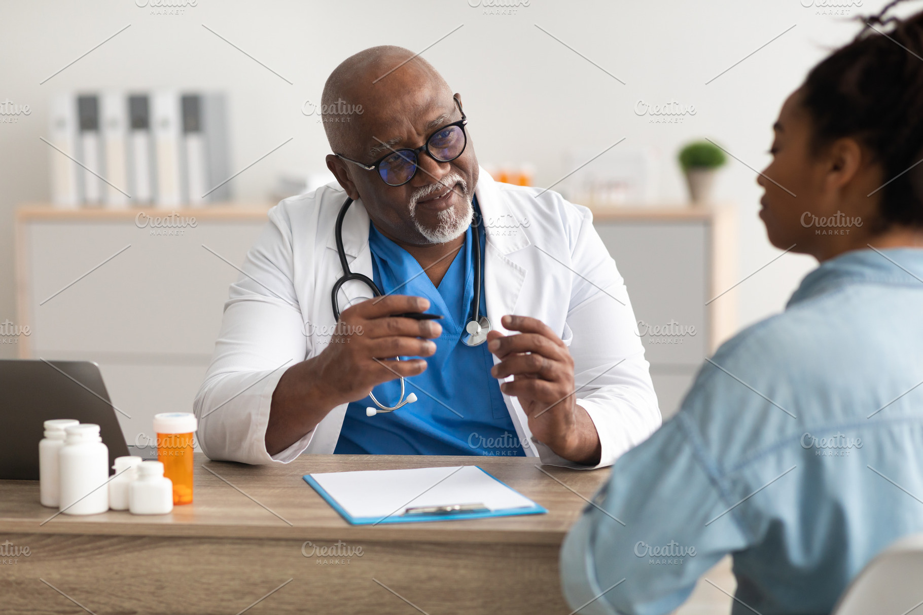 Experienced black doctor explaining treatment plan to patient, a Photo by Prostock-Studio