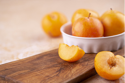 Close-up of yellow plums in a white