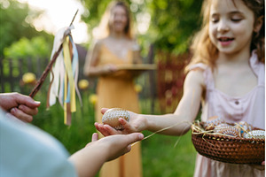 Girl giving decorated Easter eggs to, a Holiday Photo by HalfPoint