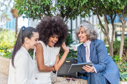 three female entrepreneurs watching something on the tablet, a Business Photo by Iván Moreno STOCK PHOTO