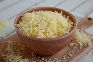 Organic Grated Cheese Mix in a Bowl, side view. Close-up., a Food & Drink Photo by LiudmylaChuhunova