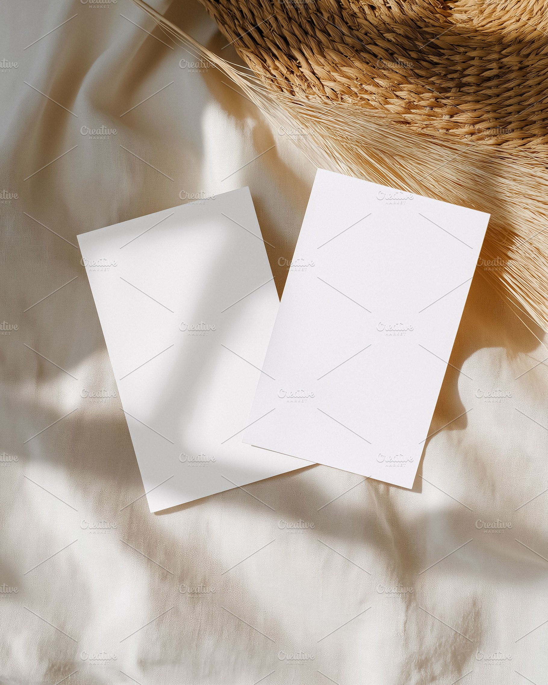 Two blank white paper cards on beige fabric with straw details, casting natural, a Holiday Photo by Studio ANNA