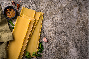 Uncooked lasagna pasta with cooking, a Food & Drink Photo by Yulia Furman