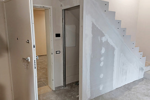 Workers renovating a house using plasterboard and stucco under the stairwell, an Architecture Photo by Antonio Gravante Market