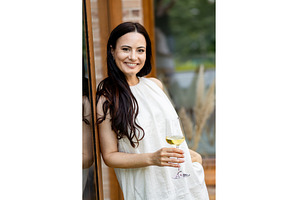 Smiling woman with glass of white, a Person Photo by HalfPoint