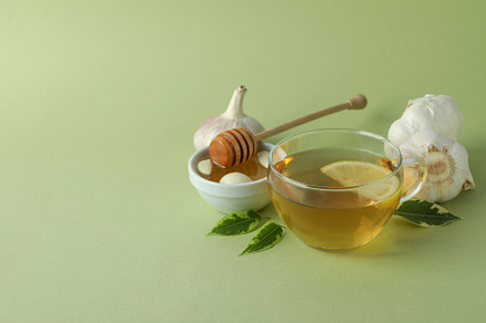 Concept of treatment colds with honey and garlic on green  backg, a Food & Drink Photo by AtlasStudio