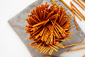 Organic Salty Pretzel Sticks in a Bowl, top view. Space for text, a Food & Drink Photo by LiudmylaChuhunova