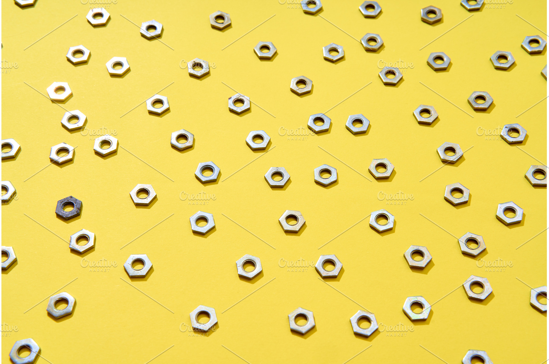 Metal nuts pattern on yellow, an Industrial Photo by Gladkov photography