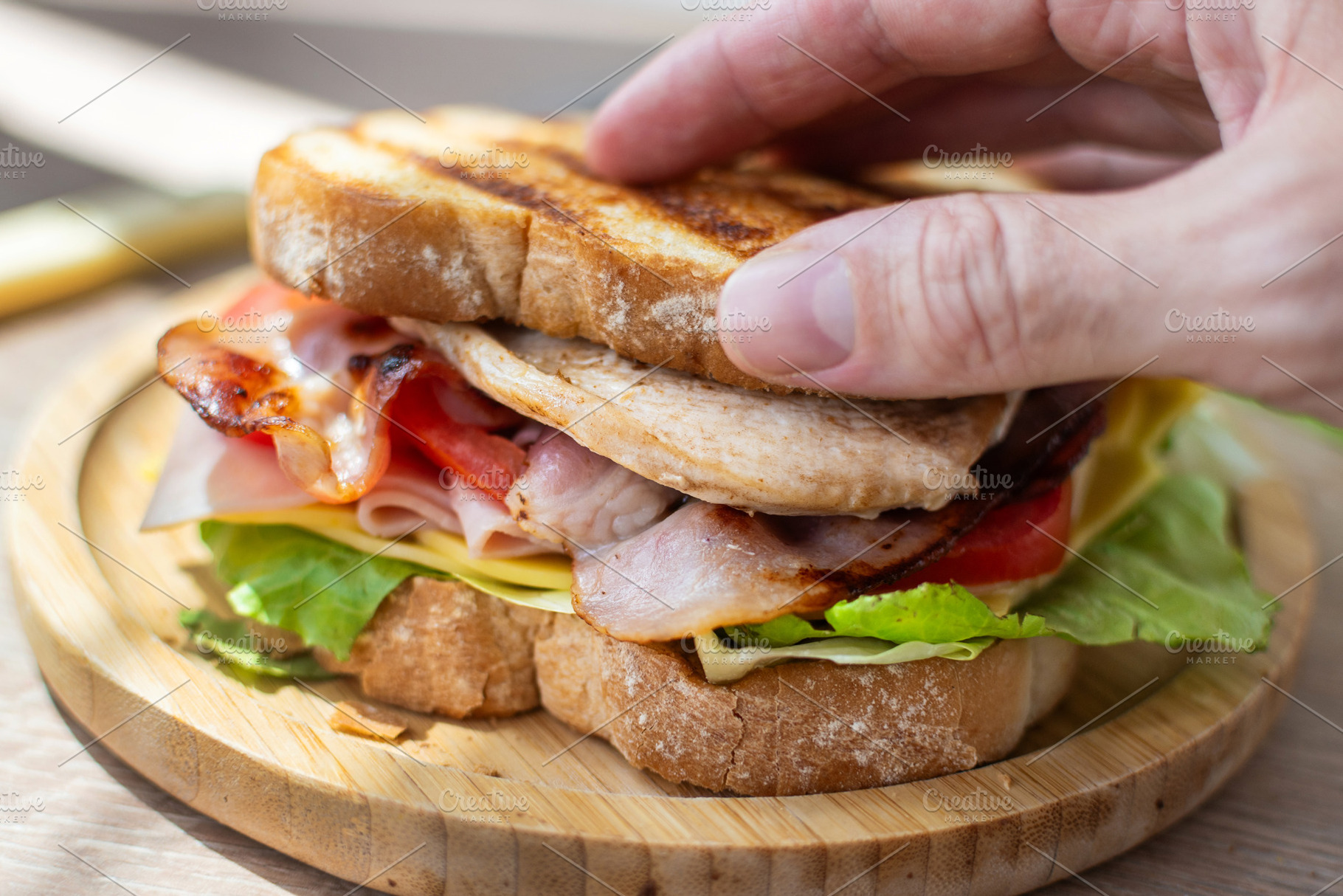 Hand Holding Fresh Club Sandwich with Bacon, Ham, Cheese and Grilled Chicken, a Food & Drink Photo by etorres69