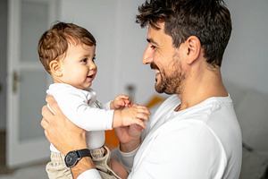 Dad holding in his arm his child at interior scene home, a Person Photo by DanFLCreativo