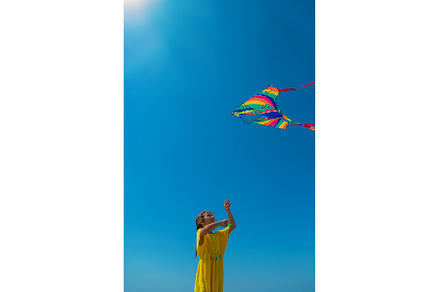 A child flies a kite on the beach, a Person Photo by yanadjana