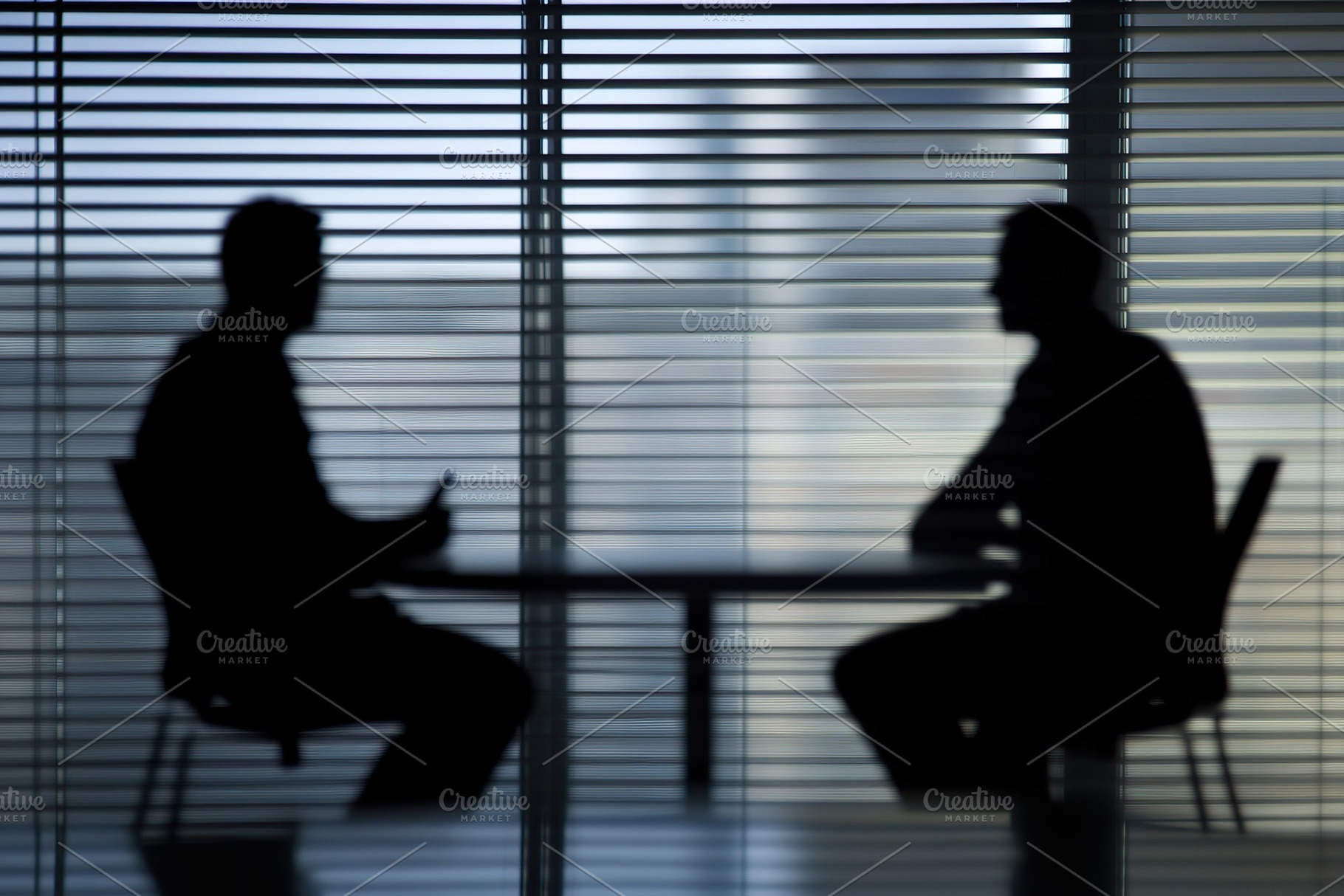 Two people engaged in conversation in a silhouetted setting by a window during, a Photo by AlyaAnd