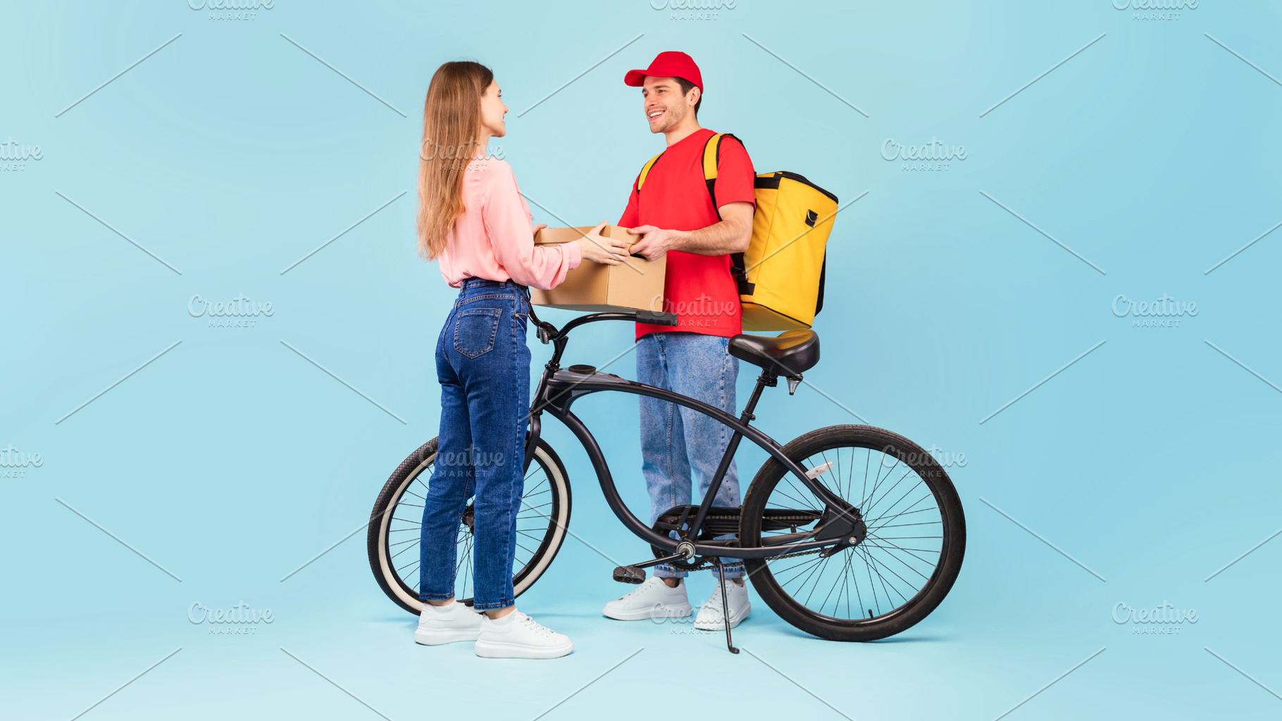 Courier Delivering Parcel To Woman Posing With Bike, Blue Background, a Photo by Prostock-Studio