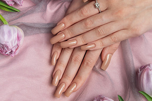 Woman showing nude manicure and diamond ring near tulips on pink, a Beauty & Fashion Photo by Olena Rudo