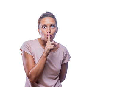 An adult woman gesturing silence while looking at camera, a Person Photo by Iván Moreno STOCK PHOTO