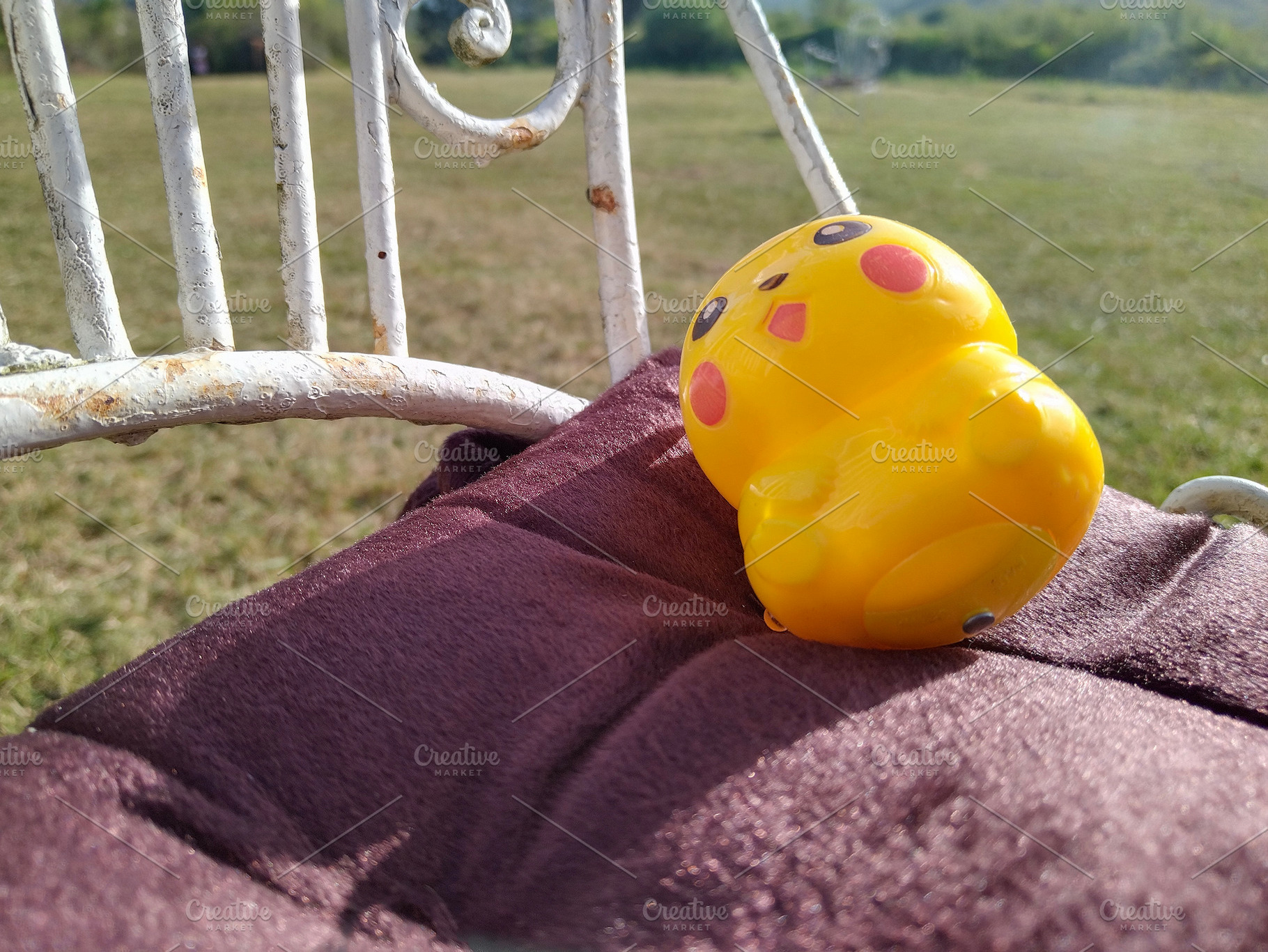 Playful yellow toy on chair in sunlit garden, an Arts & Entertainment Photo by DanFLCreativo