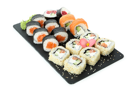 Slate board with sushi set isolated on white background, a Food & Drink Photo by AtlasStudio
