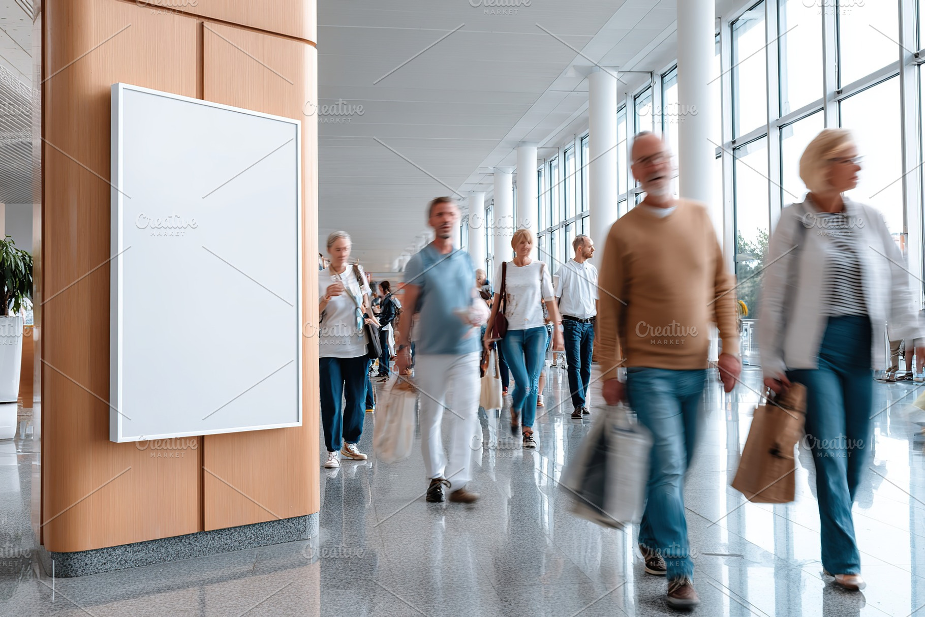 Mockup of a vertical poster displayed on a wall in a busy indoor public space, a Person Photo by AlyaAnd