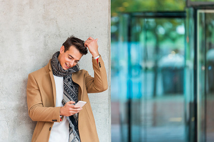 Businessman texting on mobile phone against wall, a Person Photo by RF Images