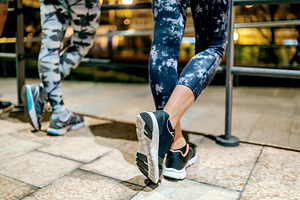 Woman runner with crossed legs resting next to female friends af