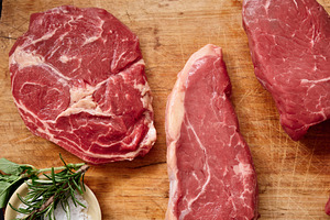 Raw rib-eye, roast beef, flank and rump steak on wooden cutting board in kitche, a Food & Drink Photo by Asya Nurullina