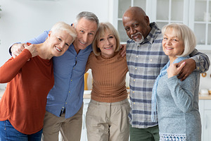 Group photo of happy elderly people hugging, smiling at camera, a Photo by Prostock-Studio