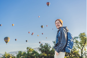 Male tourist standing with colorful, a Holiday Photo by Elizaveta Galitskaya