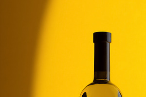 Clear glass bottle containing liquid with a black cap on a vibra, a Photo by Studio ANNA