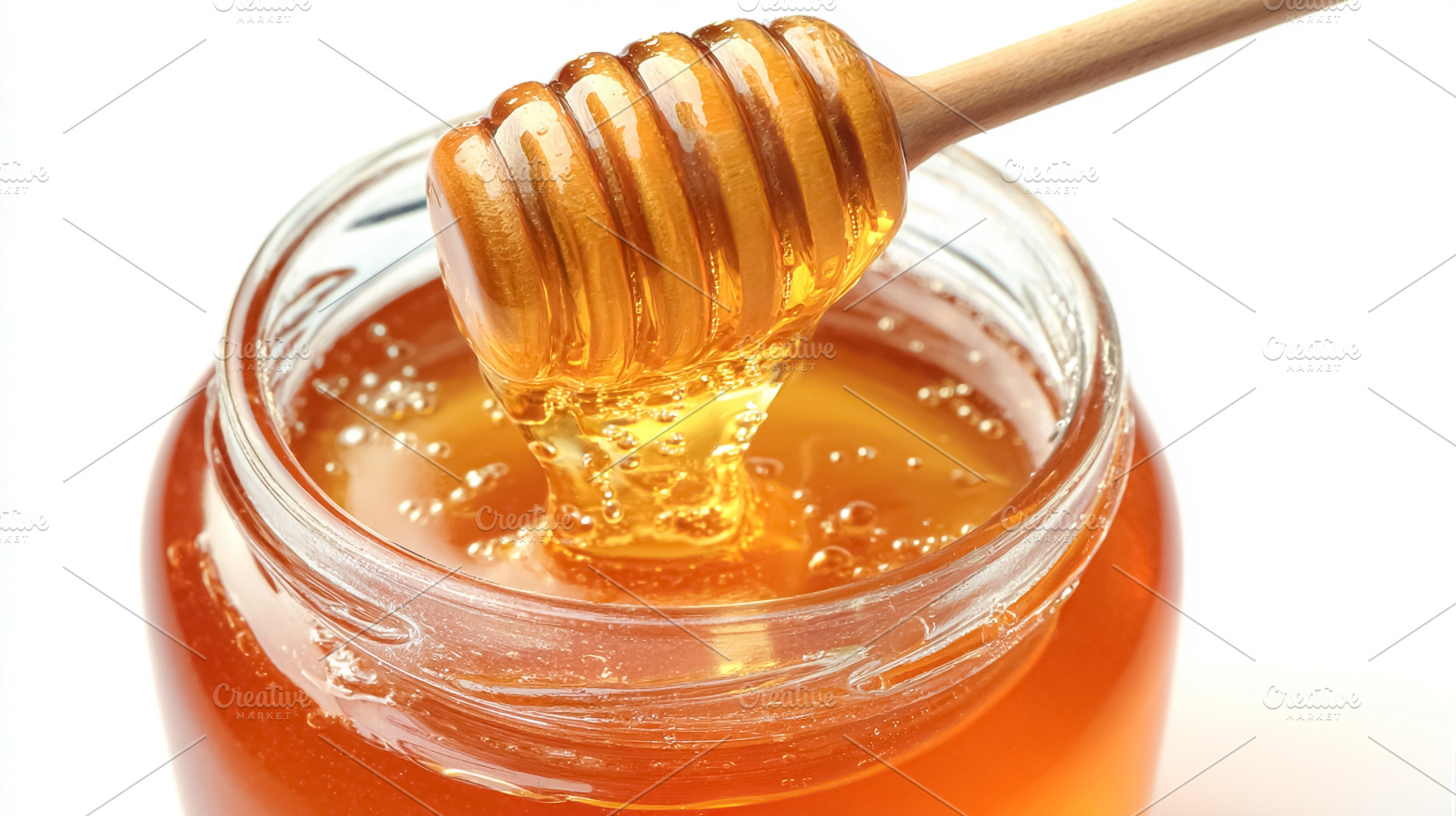 Golden honey dripping from a wooden dipper into a clear glass ja, a Photo by Studio ANNA
