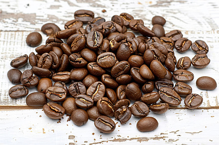 Heap of coffee beans on wooden table, a Food & Drink Photo by AlyaAnd