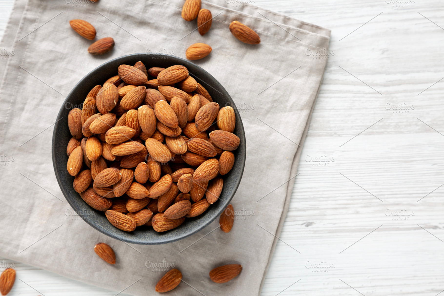 Roasted Almonds in a Bowl, top view. Copy space., a Food & Drink Photo by LiudmylaChuhunova